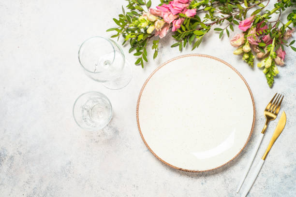 istock Table setting with white plate, cutlery and flowers. 1680718233