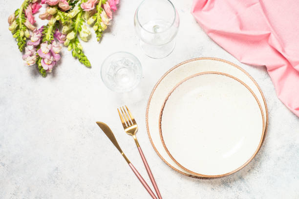istock Table setting with white plate, cutlery and flowers. 1680718245