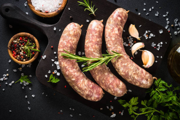 istock Bratwurst or sausages on cutting board with spices at black table. 1680773308