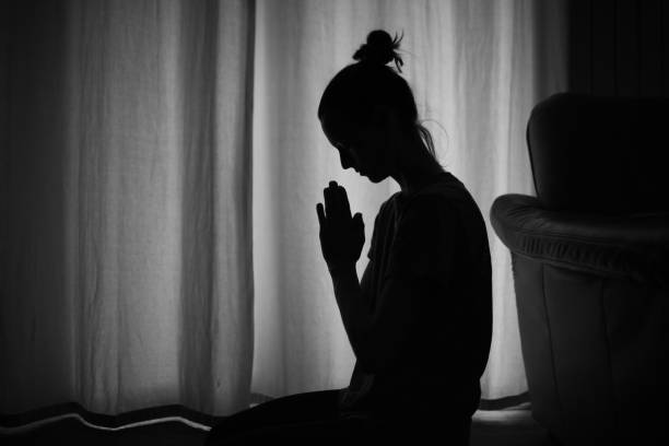 istock Young female at home saying a prayer. 1680784056