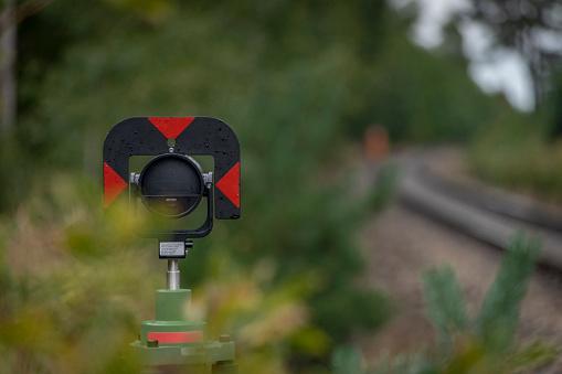 Surveyors with instruments on railway track near fresh green forest in south Bohemia