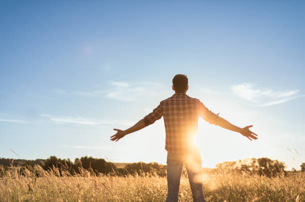 istock Young man with open arms at dawn sunrise feeling happy alive and well. 1680792010