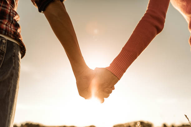 istock Romantic couple holding hands and watching a beautiful sunset. 1680793069