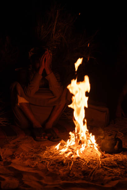 istock Unrecognizable person next to a bonfire in the dark 1680801256