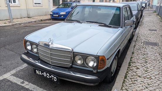 28.03.2023 In the parking lot near the house there is a retro Mercedes-Benz W123 car heavenly color