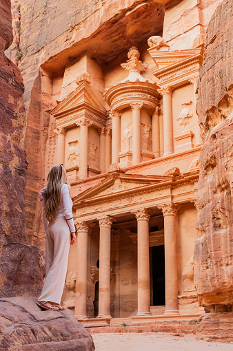 Blonde tourist woman in Al Khazneh (The Treasury), ancient city of Petra. Historical and archaeological city in southern Jordan. Travel destinations