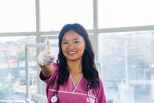 Confident Beautiful Indian Looking Nepali Dentist Doctor Girl Smiling and Giving gestures