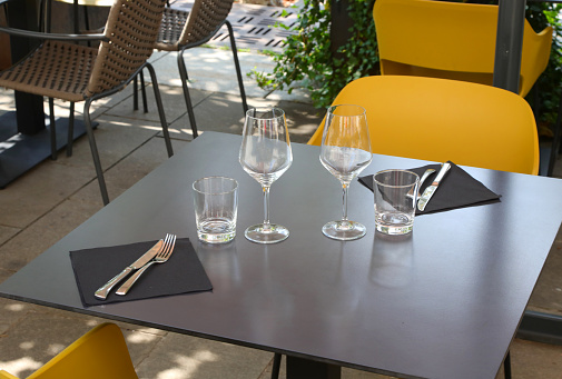 alfresco cafe table without people with glasses and cutlery in Europe