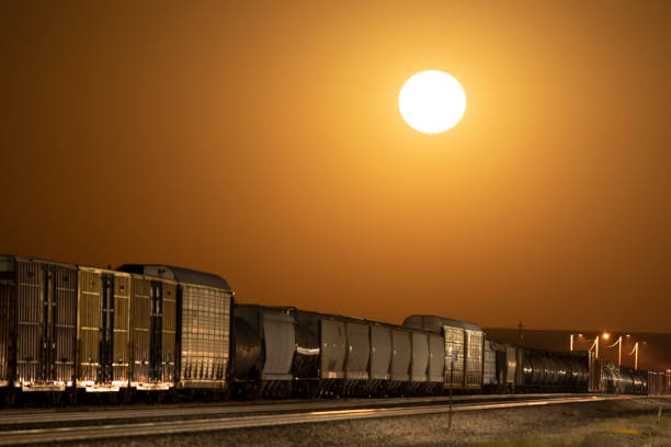istock Moon rise as an orange glowing sphere over freight train 1680876969