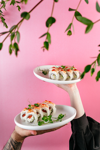 a girl holds a plate of Japanese sushi in her hands in Berlin, Berlin, Germany