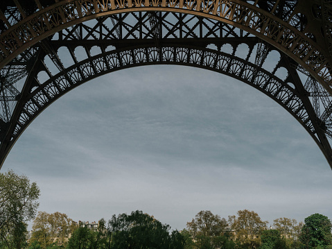 Stunning view through the bottom arch of the Eiffel Tower, in Paris, Île-de-France, France