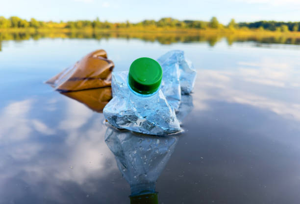 istock Plastic bottle garbage on sea shore lake. Collecting waste and garbage on beach. 1680887447