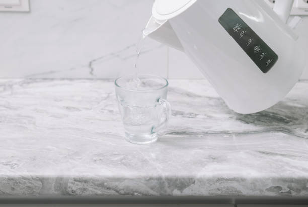 istock a man pours hot water from a white plastic teapot into a mug 1680904334