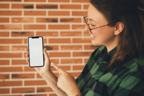 istock Woman holding smartphone with white empty screen. Place for text. 1680927482