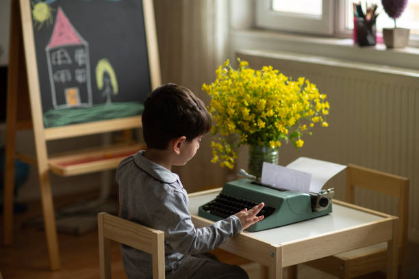 boy with typewriter - typewriter journalist newspaper obsolete imagens e fotografias de stock