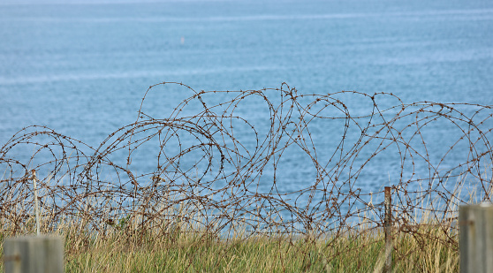 barbed wire in the border and sea in background without people