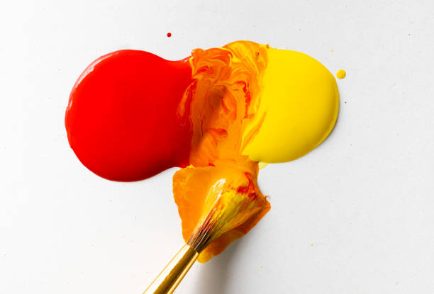 Red and Yellow Paint mixing with a paint brush to make Orange