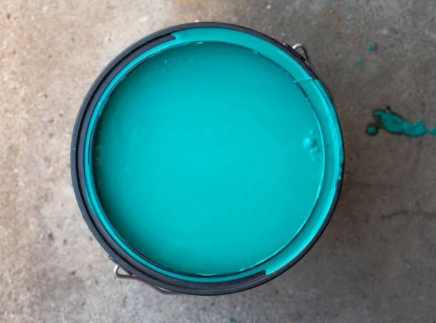 A Bucket of Teal Paint on Cement Floor