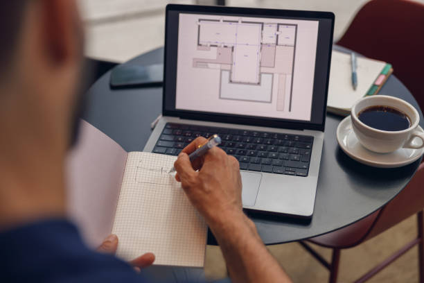 istock Close up of male architect is making notes in note pad during work on laptop in coworking space 1681028380
