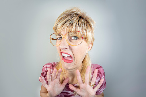 A humorous fisheye image of a woman with a mullet expressing disgust.