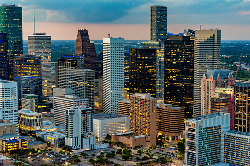 The buildings of downtown Houston, Texas illuminated at night shortly after sunset shot via helicopter from an altitude of about 900 feet.