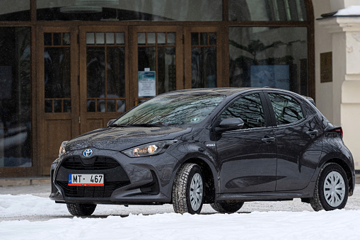 Riga, Latvia - February 9, 2021: metallic grayToyota Yaris Hybrid Y20 Edition Hatchback car parked near the residential building