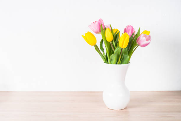 istock Tulips flower bouquet in white ceramic vase at light background. 1681083711