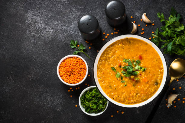 istock Lentil soup with vegetables on black stone table. 1681084781
