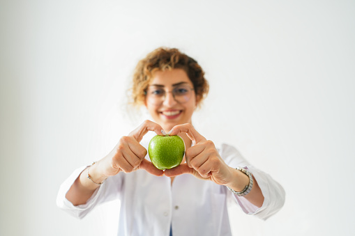 female healthy nutritionist making heart with apple. healthy lifestyle