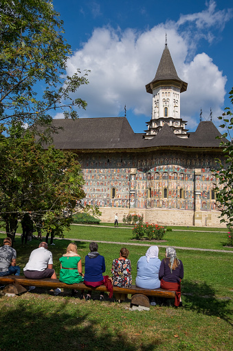 Romania, Bucovina - September 10, 2023: Parishioners in the gardens of the Sucevita Monastery