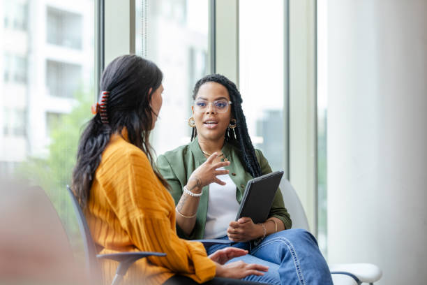 Therapy client listens to therapist discuss coping strategy stock photo