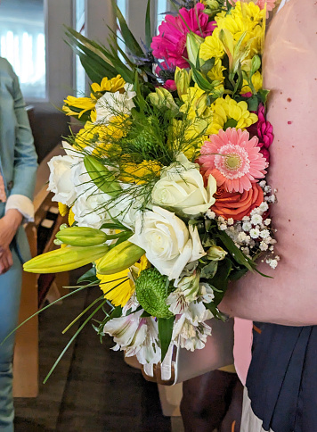 A Canadian woman holds a bouquet of flowers at her place of work.