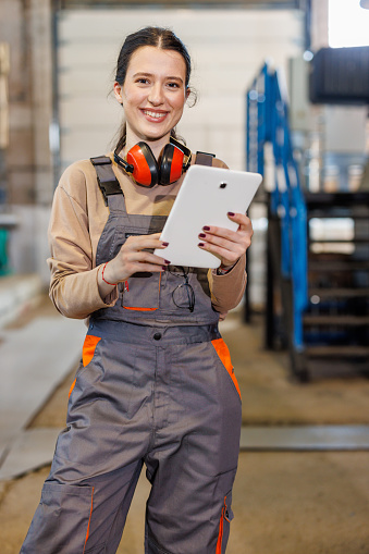 Using her digital tablet, the woman communicates with her colleagues to ensure that everyone is on the same page when it comes to managing the heating plant