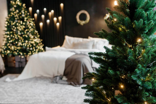istock Bedroom interior decorated for Christmas holidays. Home interior with a Christmas tree on a dark wall background. 1681112148