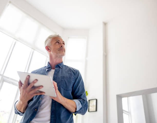 istock Man controlling his smart home on a digital tablet 1681119199