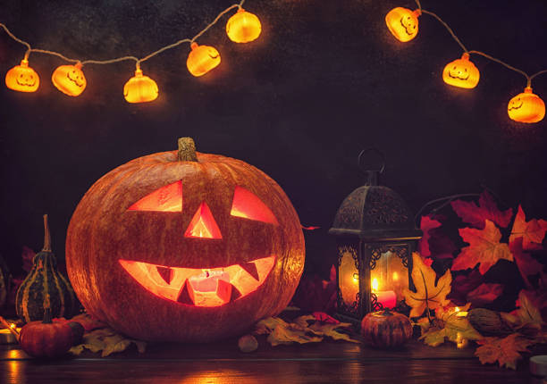 Jack O’ Lanterns glowing on the old wooden background