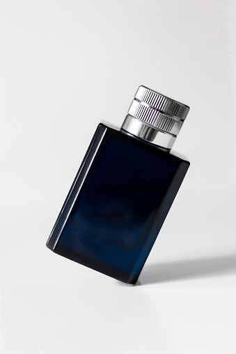Empty blue perfume glass bottle isolated on white background