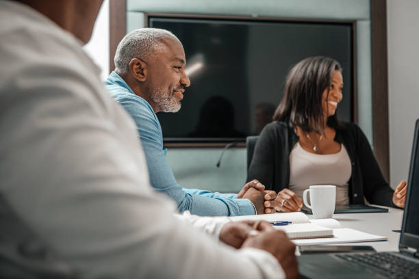 Successful over 40s black businessman leading a group office meeting stock photo
