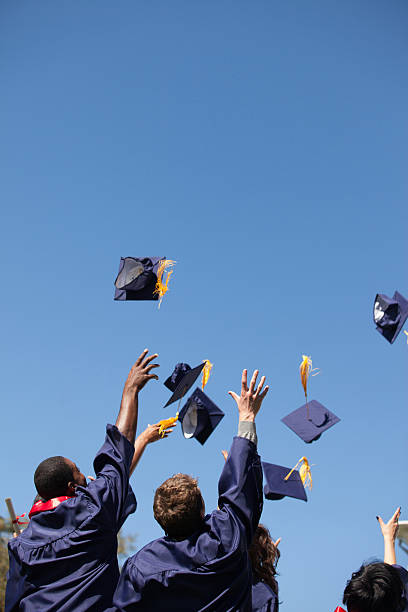 Graduates throwing caps in air outdoors  graduation photos stock pictures, royalty-free photos & images