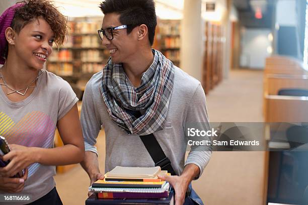 Sorridente Estudantes A Falar Na Biblioteca - Fotografias de stock e mais imagens de 18-19 Anos - 18-19 Anos, 20-24 Anos, Adulto