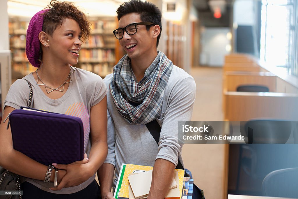 Ritratto di un sorridente studenti parlando in libreria - Foto stock royalty-free di 18-19 anni