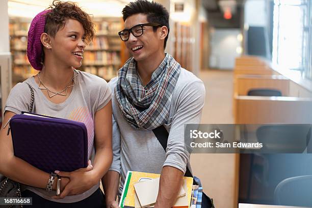 Ritratto Di Un Sorridente Studenti Parlando In Libreria - Fotografie stock e altre immagini di 18-19 anni