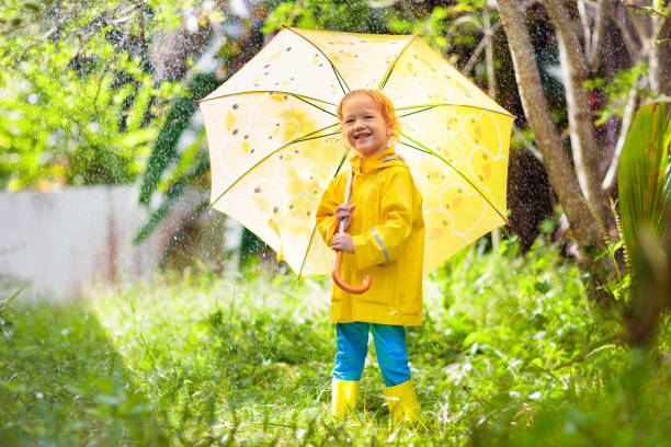 istock Child playing in the rain. Kid with umbrella. 1681171952