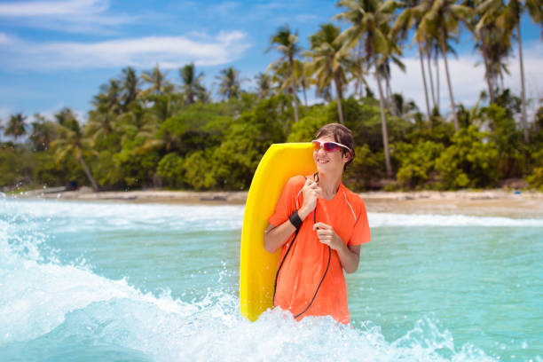 istock Child surfing on tropical beach. Surfer in ocean. 1681188905