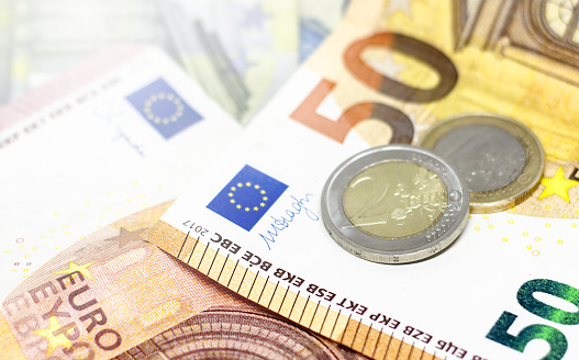 Close-up view of Euro banknotes and coins. The single European currency in use in the European Union.