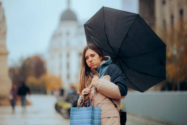 istock Stressed Woman Walking in the Rain with Broken Umbrella 1681361189