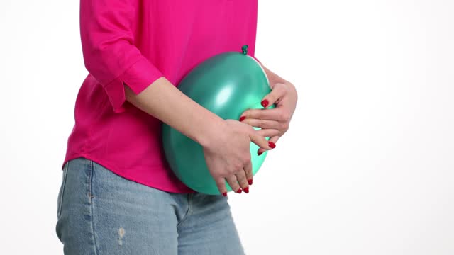 Woman is holding large green balloon as sign of bloating