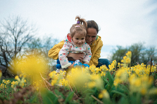 Nature lovers. Mother-daughter time among blooming primroses.