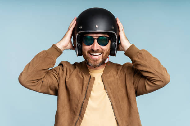 istock Joyful smiling bearded man, biker holding hands on helmet posing 1681429238