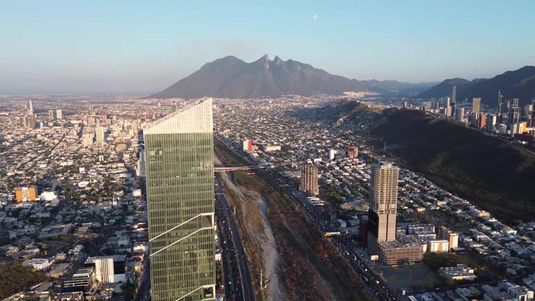 Great building in the middle of the city of the mountains and below it many cars in the distance you see a great hill and a great metropolis